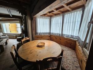 una mesa de madera en una habitación con ventanas en IMEDA CASA LOS PINOS en Sierra Nevada