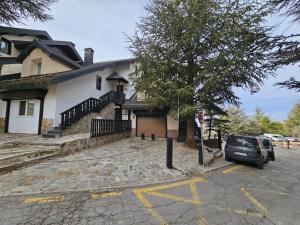 un coche aparcado en un estacionamiento frente a una casa en IMEDA CASA LOS PINOS, en Sierra Nevada