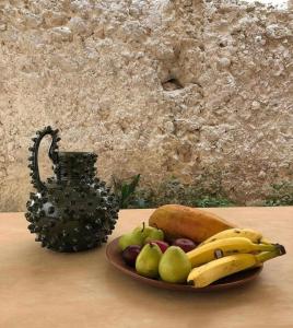 une assiette de fruits sur une table avec un vase dans l'établissement Bajo las Hojas, à Campeche