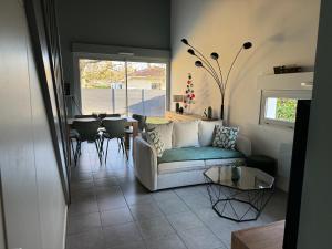 uma sala de estar com um sofá e uma mesa em MAISON PINTOUN em Heugas