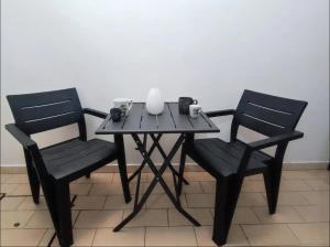 Dos sillas y una mesa con una vela. en Camere Aeroporto Cagliari Elmas, en Elmas