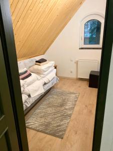 a attic room with a bed and a rug at Dolce Vita in Ustroń