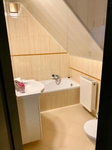 ein Badezimmer mit einem Waschbecken und einer Badewanne in der Unterkunft Dolce Vita in Ustroń