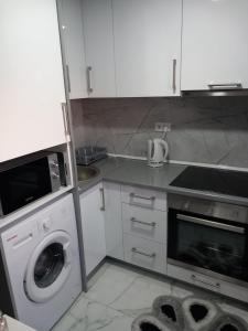 a kitchen with a washing machine and a washer at Apartment B&E in Tuzla