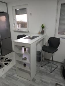 a small white desk with a chair and a window at Apartment B&E in Tuzla +12 photos