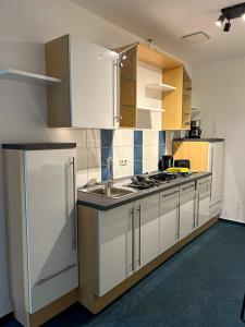 a kitchen with white cabinets and a sink at BM Rooms - Bamberger Gemütlichkeit in Bamberg