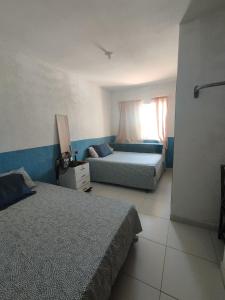 um quarto com 2 camas e uma janela em Recanto Casa SOL em Barra de Jacuípe
