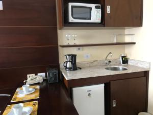 a small kitchen with a sink and a microwave at Delicioso flat em área nobre in Sao Paulo