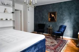 een slaapkamer met 2 blauwe stoelen en een bed bij Exklusiv takvåning i lantlig miljö in Falun