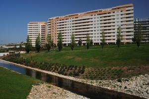 ein großes Apartmenthaus mit einem Park neben einem Fluss in der Unterkunft Cardoso Pires 2 Bedrooms Apt. in Lissabon