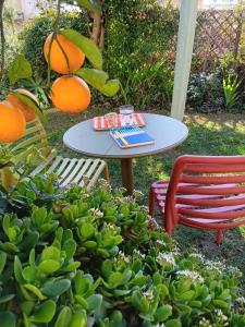 une table et deux chaises, une table et des oranges dans l'établissement Il Giardino Di Tatiana Rooms & Breakfast, à La Maddalena