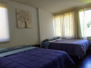 two beds in a room with purple sheets at Linda casa de campo con todas las comodidades de la ciudad in Cochabamba