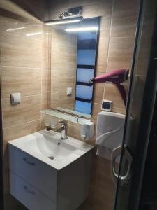 a bathroom with a white sink and a mirror at Comfort Stay, EV, Parking in Bolesławiec