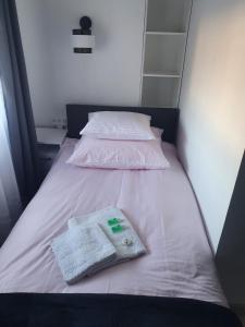 a bed with two white pillows and a towel on it at Comfort Stay, EV, Parking in Bolesławiec
