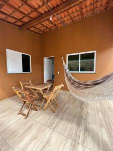 Casita lagoa paraíso في جيجوكا دي جيريكواكوارا: أرجوحة في غرفة مع طاولة وكراسي