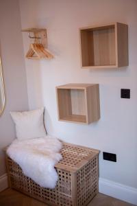 a room with a wicker chair with a white pillow at Broad Street Apartments - Central Bath in Bath