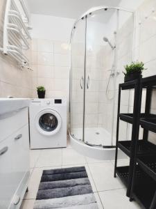 a bathroom with a washing machine and a shower at Dobre Sny na Konopnej in Bydgoszcz