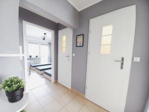 a hallway with a white door with a plant on the floor at Dobre Sny na Konopnej in Bydgoszcz