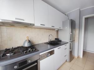 a kitchen with white cabinets and a sink and a stove at Dobre Sny na Konopnej in Bydgoszcz