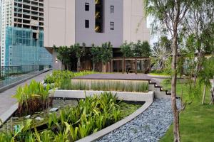 un jardin avec des rochers et des plantes devant un bâtiment dans l'établissement The Ress - The Axon Bukit Bintang Residence, à Kuala Lumpur