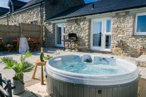 a hot tub in the backyard of a house at Cysgod y Llanw in Llanfaethlu