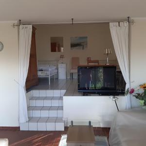 a living room with a flat screen tv and stairs at Ferienwohnung Zentrumsnah in Heppenheim in Heppenheim an der Bergstrasse