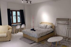a bedroom with a bed and a chair and a table at 5-Person 1950s Shophouse: Vintage Charm & Smart TVs in Taiping