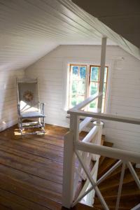 an attic room with a staircase and a chair at Scoutstugan in Falun