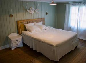 a bedroom with a large bed with a white comforter at Scoutstugan in Falun