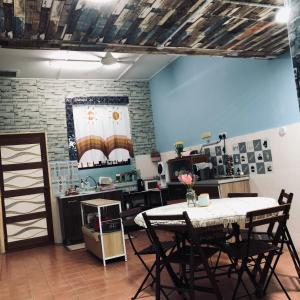 a kitchen with a table and chairs in a room at E&Y Inn in Kampong Tanjong Tengku