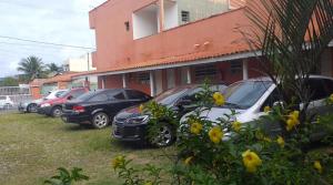 a row of cars parked in front of a building at Pousada Iguape Apartamentos - Unidade Ilha Comprida in Ilha Comprida