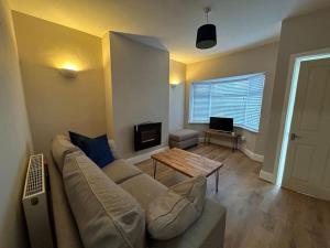 a living room with a couch and a table at Cosy yet spacious bungalow in Saughall