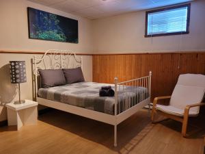 ein Schlafzimmer mit einem weißen Bett und einem Stuhl in der Unterkunft Le Bethel Quiet and Peaceful Place in Namur