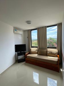 Habitación con cama y ventana con TV. en SORRENTO Céntrico en Villa Carlos Paz