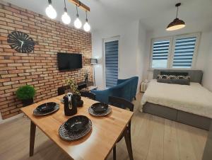 een woonkamer met een bed en een tafel in een kamer bij Nova Town Apartament in Stargard