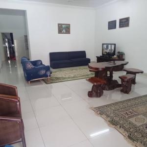 Homestay Ambangan Height SP في سونغاي بيتاني: غرفة معيشة مع أريكة وطاولة وكراسي