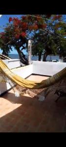 un'amaca su una spiaggia con alberi sullo sfondo di Lindo Apartamento: centro, terraço com linda vista mar e tudo perto! a Porto Seguro