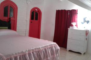 una camera da letto con porte rosse, un letto e una cassettiera di Lindo Apartamento: centro, terraço com linda vista mar e tudo perto! a Porto Seguro