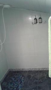 un bagno con una parete bianca con due bottiglie su uno scaffale di Lindo Apartamento: centro, terraço com linda vista mar e tudo perto! a Porto Seguro