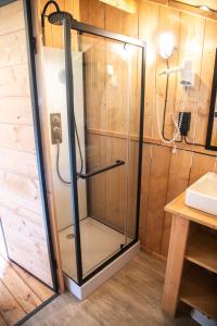 a shower with a glass door in a bathroom at Glampingzelt Heide - Lodge in Soltau