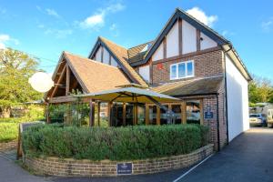 un edificio con una sombrilla delante de él en Entire Apartment in Central Brockenhurst, en Brockenhurst