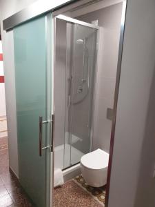 a bathroom with a toilet and a glass shower stall at Nautilus Hotel in La Spezia