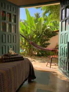 Pokój z łóżkiem i hamakiem na patio w obiekcie Pousada Hostal das Estrelas w mieście Praia do Frances