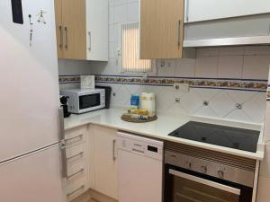 a kitchen with a microwave and a stove top oven at Apartamento Calypso in Cabo de Palos +7 photos