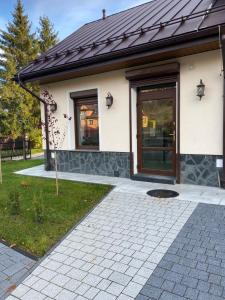 a house with a front door and a patio at Apartamenty Natalii in Nowy Targ