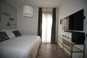 een slaapkamer met een bed en een flatscreen-tv bij Élite Suite Home in Termoli