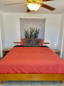 Casa Tranquila في رينكون: غرفة نوم بسرير ولحاف احمر