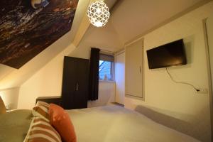 1 dormitorio con 1 cama y TV en la pared en Hotelkamer de Loft, en Anjum