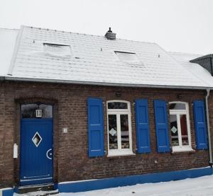 ein Backsteingebäude mit blauen Türen und Fenstern in der Unterkunft Diana's Stube in Krefeld