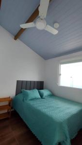 a bedroom with a bed with a ceiling fan at Casa Silandia, tu casa en Búzios in Búzios